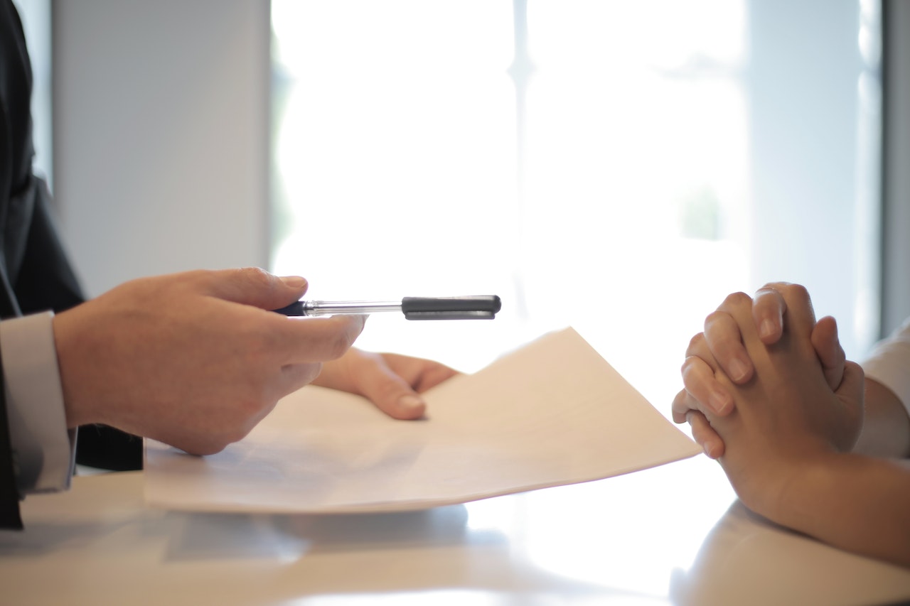 Une personne veut faire signer un contrat à une autre qui semble réticente. Les nouvelles réglementations liées à la la transition énergétique peuvent engendrer une augmentation des termes et conditions des baux commerciaux.